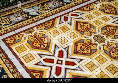 Floor tiles with arabesque ornaments in yellow, white and red colors. Stock Photo