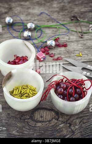 Buttons, threads and beads on wooden countertop on the background box with accessories Stock Photo