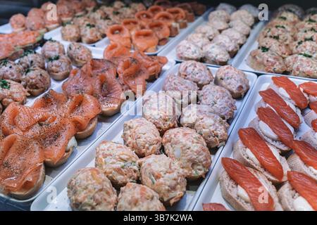Assorted salmon tapas on display in Mercado de San Miguel, Madrid. Stock Photo