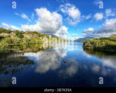 Golden hour over Llyn Padarn lake in Snowdonia National Park, Wales with tranquil water and mountain views. Stock Photo