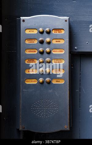 Venice, Italy - 25 july 2020: Blue door intercom with yellow buttons and caller names on a blue wooden wall Stock Photo