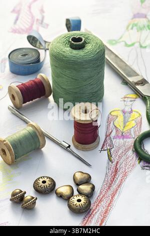 Spools of thread for sewing on the background of the sketch clothing Stock Photo