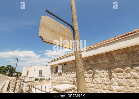 Wooden blank signboard on a pillar on the background of brick buildings. Stock Photo