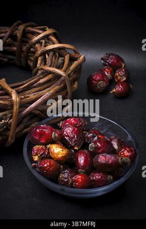 Berries are dried rose hips and herbs on black background Stock Photo