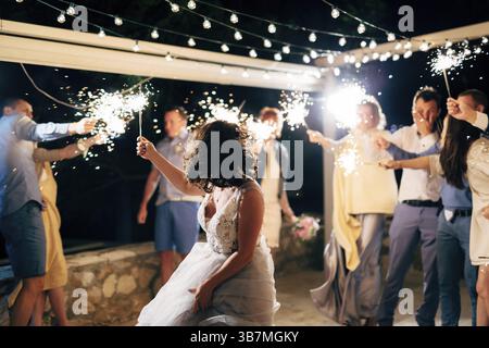 Budva, Montenegro - 21 august 2020: bride dancing among guests with sparklers at the wedding party Stock Photo