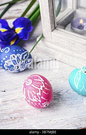 Decorated with painted Easter eggs and flowers on a light background Stock Photo