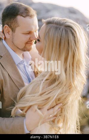 Groom hugs bride in a white dress. Close-up. Stock Photo