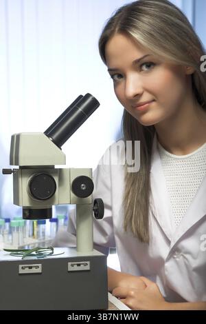 Beauty researcher looking through microscope in laboratory Stock Photo