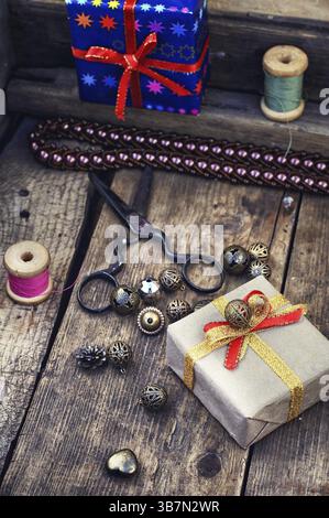 Old scissors, spools of thread, buttons and beads on wooden table Stock Photo