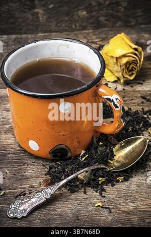 Enamel cup with herbal tea amid scattered on the welding table.selective focus Stock Photo