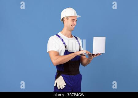 Handsome Young Foreman Guy With Laptop, Ordering Construction Materials Online Stock Photo
