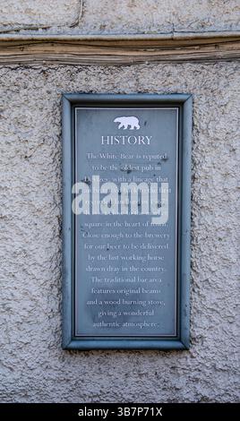 Plaque on a stone wall detailing the history of The White Bear, reputedly the oldest pub in Devizes with a centuries-old heritage Stock Photo