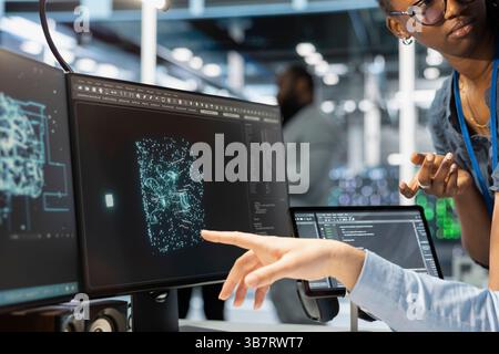 Close up of manager supervising admin using computer in data center office, integrating AI driven automation tools. Server farm team leader and worker use artificial intelligence deep learning models Stock Photo