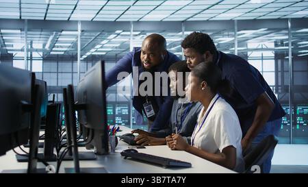 Coworkers in data center doing brainstorming, implementing AI predictive maintenance systems. Server hub colleagues discussing, using artificial intelligence to identify hardware failures, camera A Stock Photo