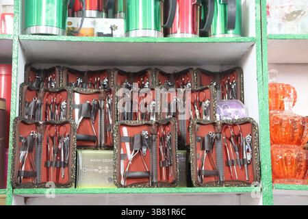 Neatly arranged manicure kits in patterned zip cases and stacked glassware feature prominently on shelves, showcasing a diverse array of available hou Stock Photo