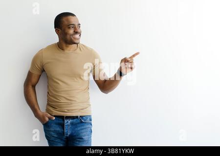 Look There. Young Black Man Pointing Aside At Copy Space With Finger Stock Photo
