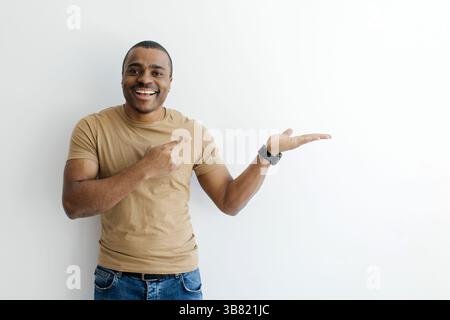 Cheerful Black Man Pointing Finger At Open Palm, Demonstrating Something Stock Photo