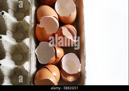 Broken eggshells in a cardboard egg container. Directly above. Copy space. Stock Photo