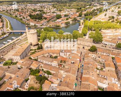 Aigues-Mortes, Camargue, France, medieval city with its surrounding walls, the Constance Tower, and typical southern french houses, canals for boats Stock Photo