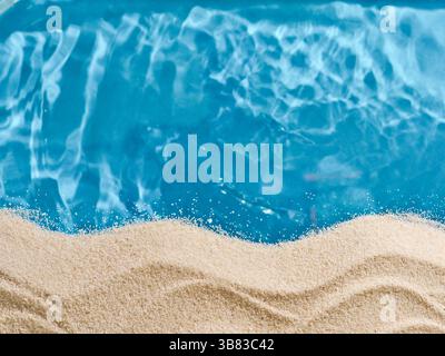 Summer blue background with sand on edges and blue background sea water with wave in center for copy space Tourism, vacation and holidays concept Stock Photo