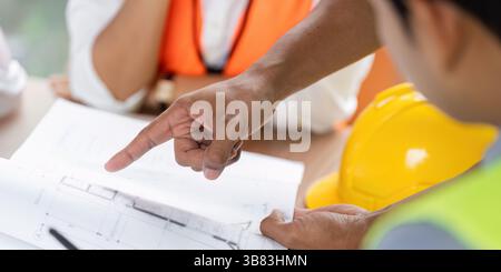 Green tech engineers analyzing plans for sustainable construction Stock Photo