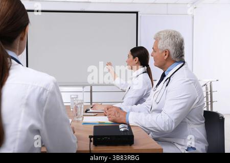 Team of doctors using video projector during conference indoors Stock Photo