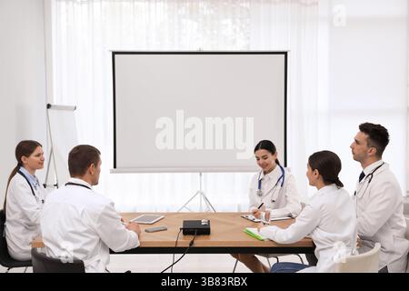 Team of doctors using video projector during conference indoors Stock Photo