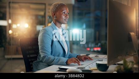 Night, business and black woman typing on computer for email, report or compliance officer on deadline. Keyboard, writing and worker reading for Stock Photo