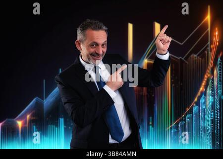 Confident businessman in suit smiling and pointing at an upward trending digital chart in a futuristic environment. Concept of business growth and suc Stock Photo