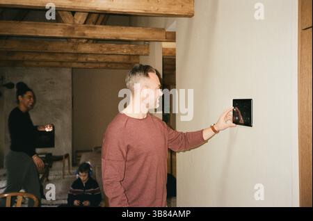 Smiling man using tablet PC mounted on wall at home Stock Photo