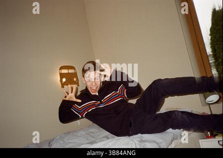 Portrait of playful boy gesturing while jumping on bed in bedroom at home Stock Photo