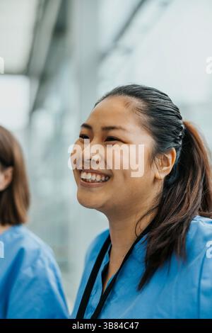 Happy young female medical professional looking away Stock Photo