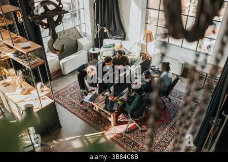 High angle view of multiracial software engineers coding while working sitting at desk in startup office Stock Photo