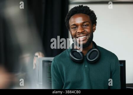 Portrait of male software engineer with wireless headphones around neck in tech startup office Stock Photo