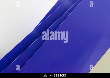 diagonal geometric and abstract composition formed by blue shelves arranged on a white wall resulting in a set of diagonal lines Stock Photo
