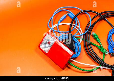 Open lantern with many wires of different colors coming out, on an orange surface Stock Photo