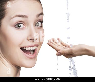 Beautiful woman face and splashes of water in hands. Cleansing and moisturizing concept Stock Photo