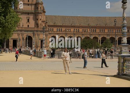 Visitors at Plaza de España in Seville during Feria de Sevilla 2025, enjoying sunshine, architecture, and festive Andalusian atmosphere. Stock Photo
