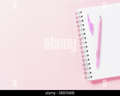 Top view of blank note paper with pen on pink pastel background. Copy space. Back to school and education concept Stock Photo