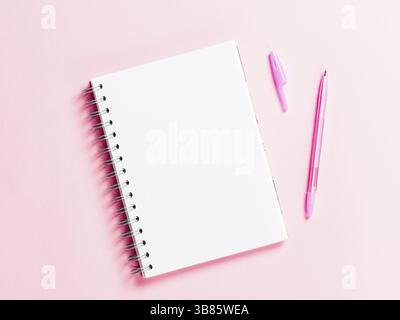 Top view of blank note paper with pen on pink pastel background. Copy space. Back to school and education concept Stock Photo
