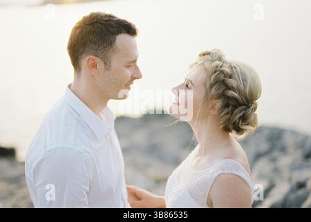 Bride and groom look into each other eyes smiling. Portrait. Stock Photo