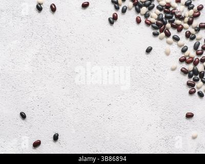 Top view of raw mixed beans on gray concrete background. Mixed of uncoocked black, red and white beans with copy space. Fodd background. Vegan protein Stock Photo