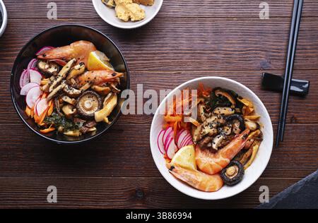 Miso soup with mussels, shrimps, shiitake mushrooms and vegatables. served at dark brown wooden table. flat lay Stock Photo