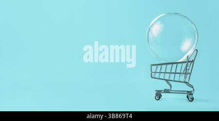 Shopping cart with soap bubble on bright blue background. Ephemeral happiness from shopping, shopaholism, consumerism concept. Shopping concept, minim Stock Photo