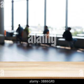 Wooden board empty table in front of blurred background. Perspective light wood table over blur silhouettes of people sitting in a cafe.. Mock up for Stock Photo