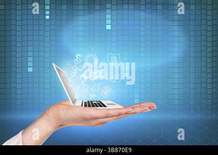 Laptop on the hand with blue matrix background and symbols Stock Photo