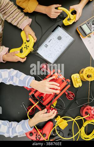 Group of students collaborating on an educational tech project, using various gadgets and tools for creating and innovating STEM projects in colorful, Stock Photo