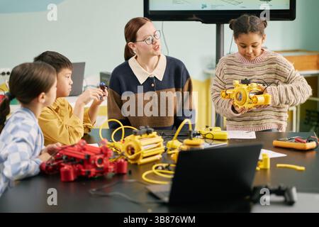 Group of students collaborating and exploring robotics with various components in classroom setting. Engaging and learning with active participation a Stock Photo