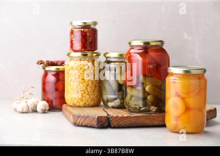 Many jars with different pickled products on light table Stock Photo