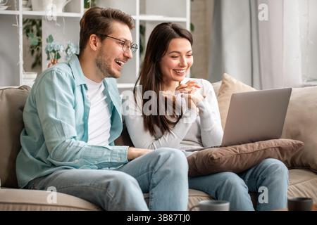 A Joyful and Happy Couple Enjoying Quality Time Together While Using Their Laptop Stock Photo